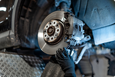 Close-up of a brake rotor and caliper being serviced
