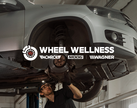 Technician inspecting a vehicle's suspension on a lift — Wheel Wellness