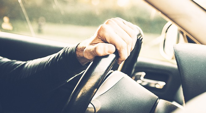 Driver-With-Hand-On-Steering-Wheel