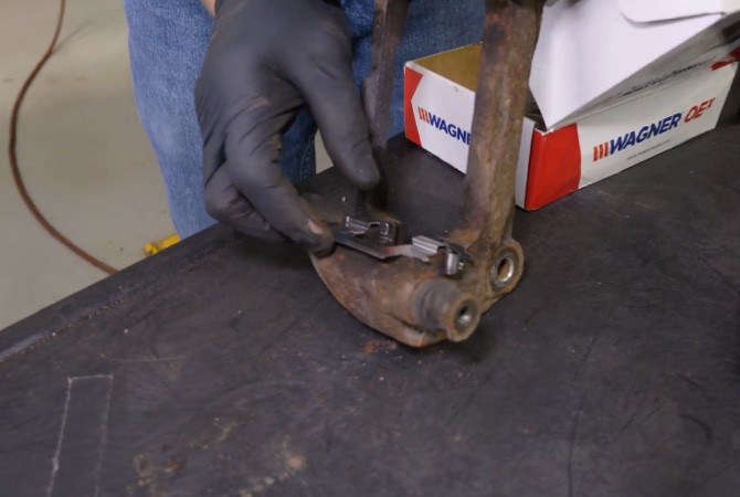 Technician installing new brake caliper hardware 