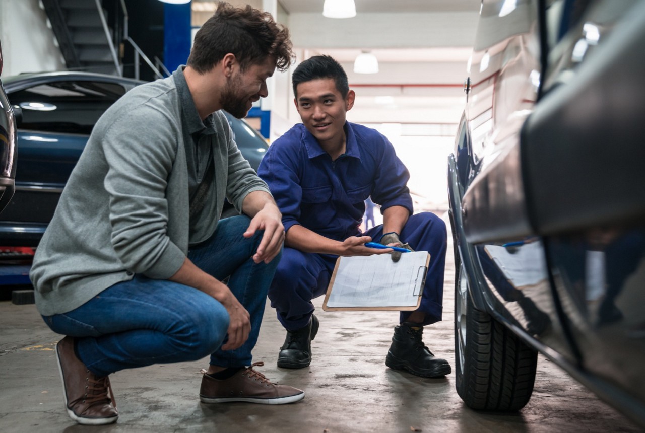Auto Mechanic Reviewing Car Repairs with Client