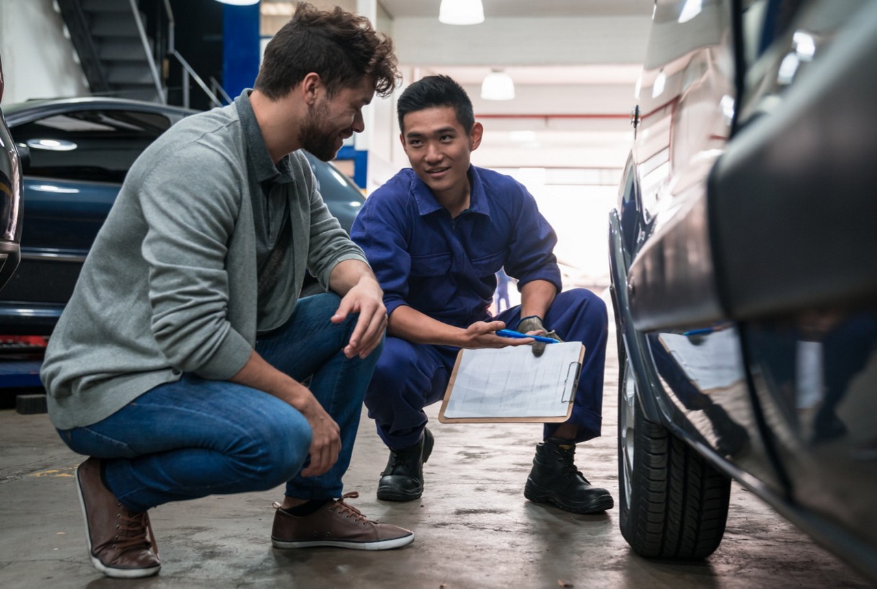 Auto Mechanic Reviewing Car Repairs with Client Auto Mechanic Reviewing Car Repairs with Client